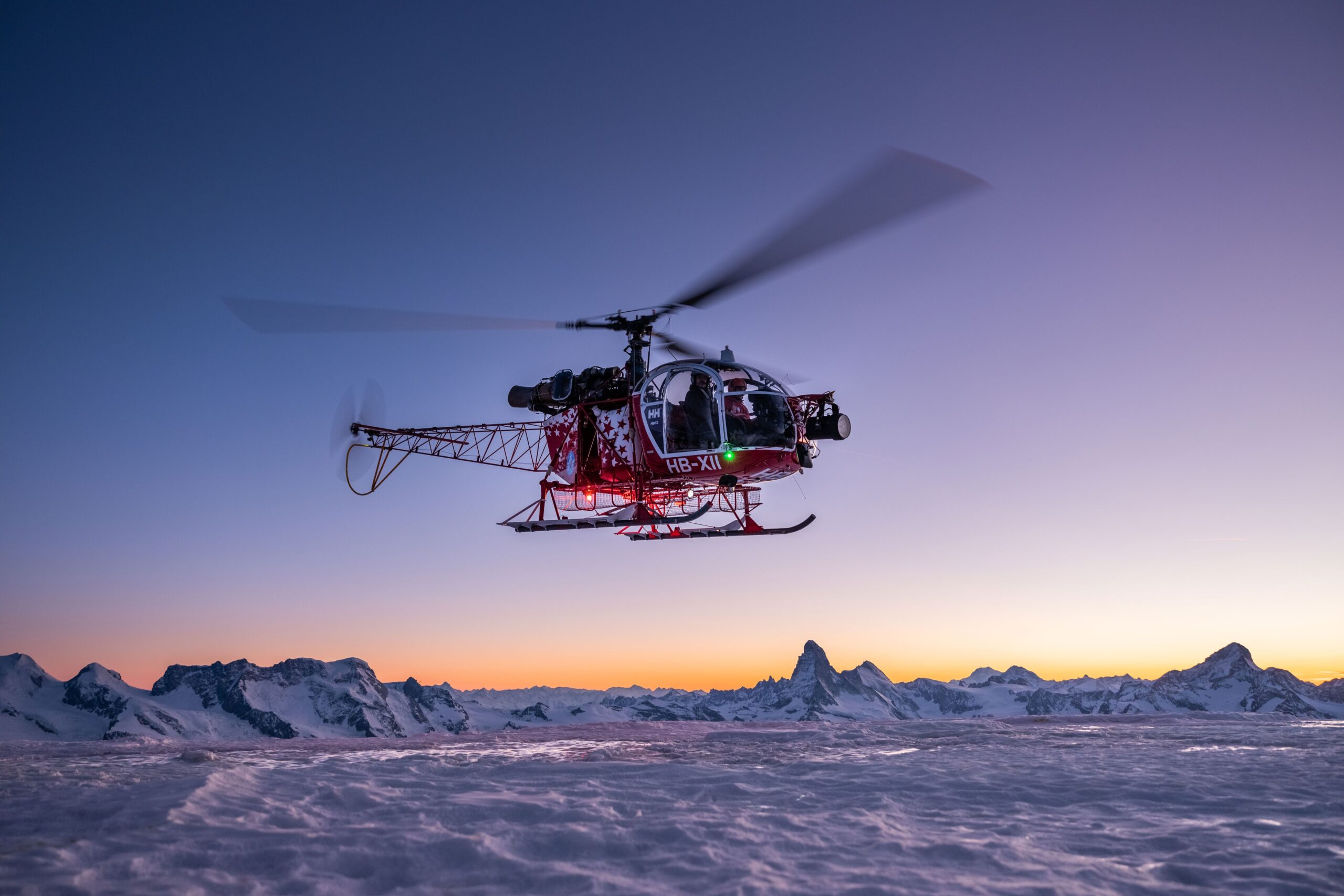 Helikopter fliegt vor dem Matterhorn bei Zermatt